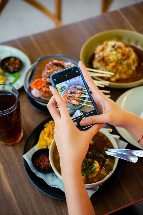 Woman Hands Holding Smartphone and Taking Pictures of Food
