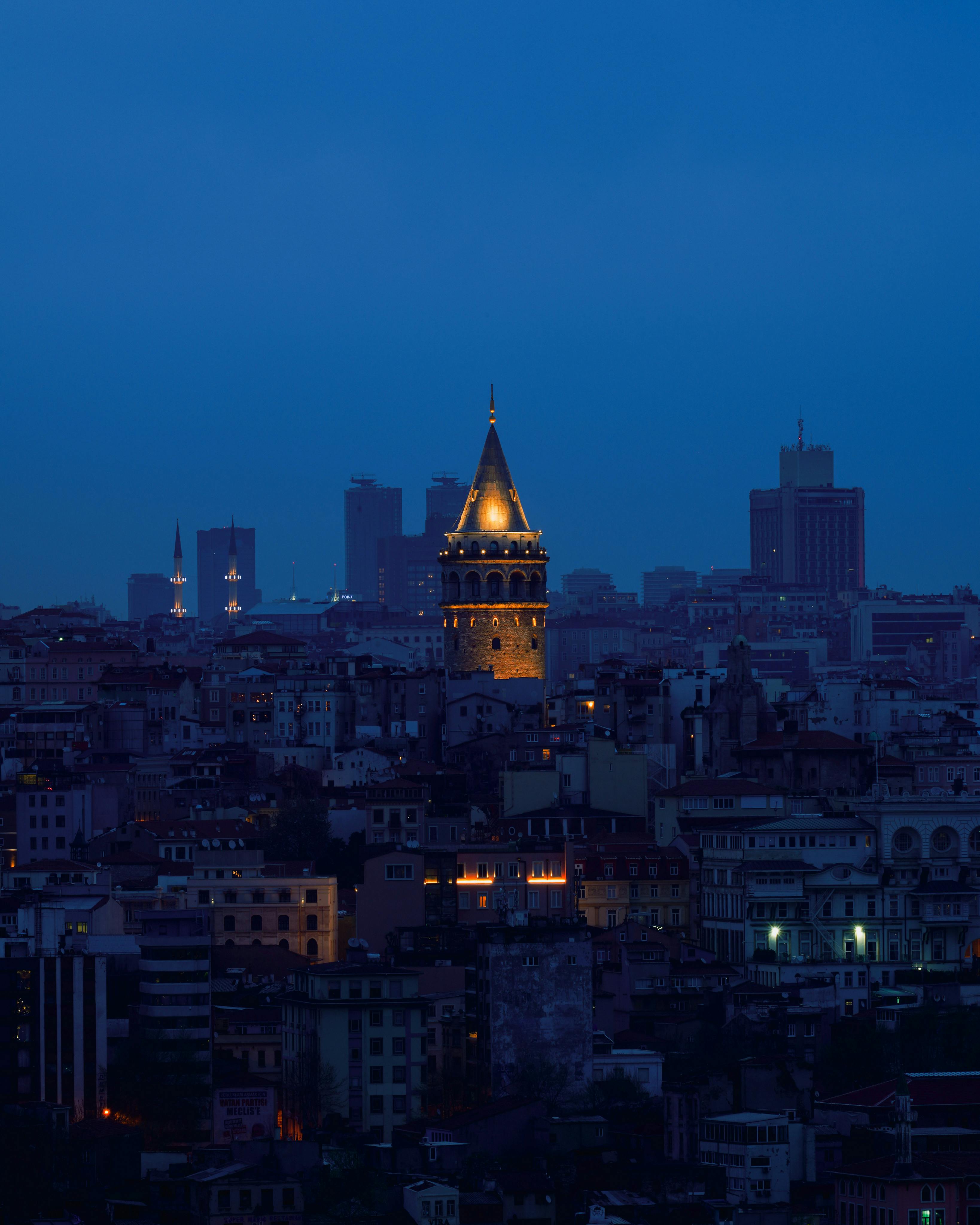 A stunning view of the illuminated Galata Tower amid Istanbul's cityscape at night.
