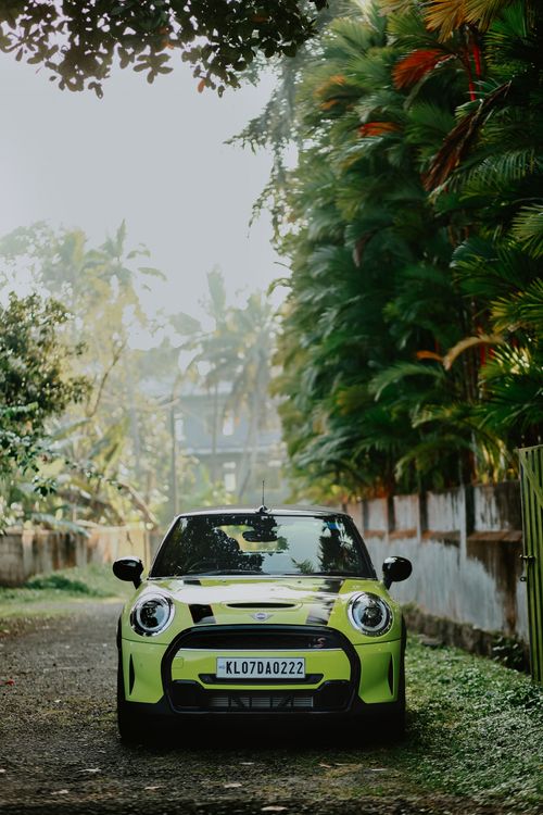 Free Bright green Mini Cooper parked in a lush alleyway in Kolenchery, Kerala, India. Stock Photo