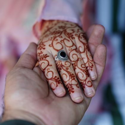 Henna-decorated hands resting together