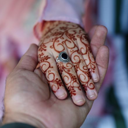 Henna-decorated hands resting together