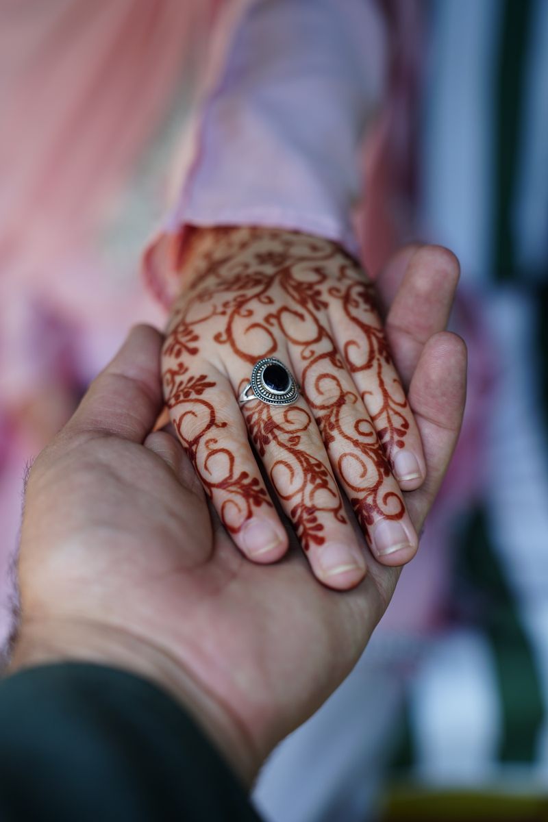 Close-up of man and woman hands with henna tattoo
