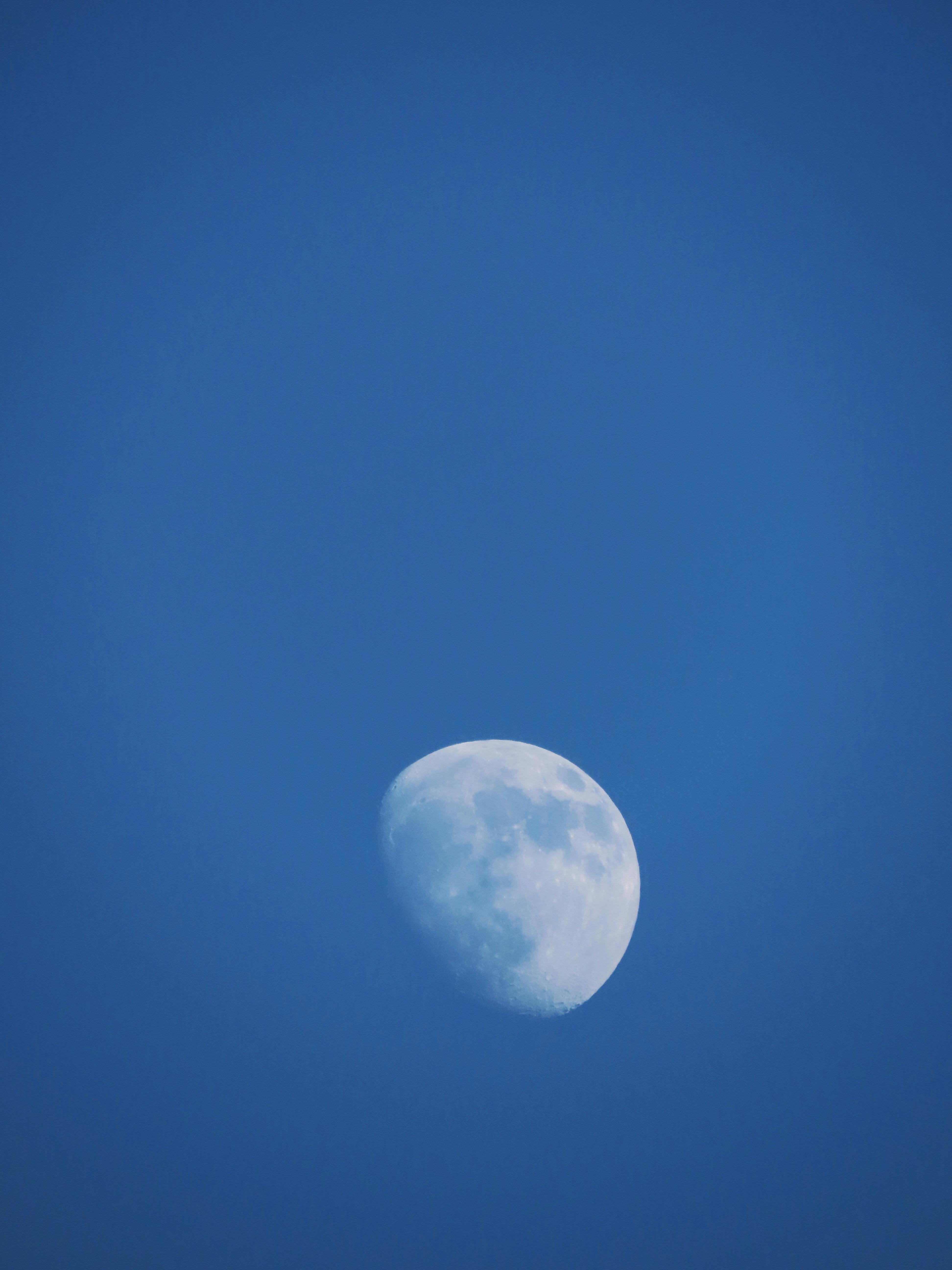 A vibrant half-moon set against a clear blue sky, captured in Rijeka, Croatia.