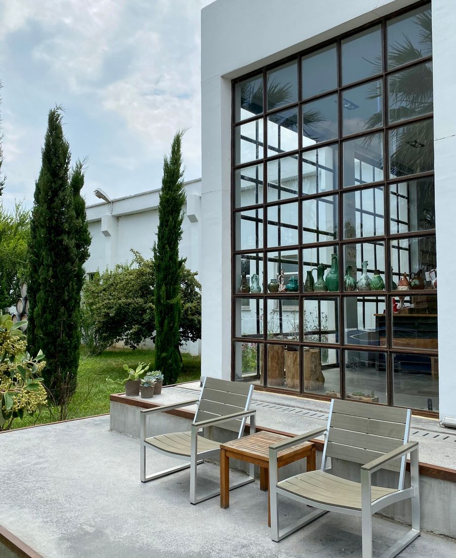 Façade vitrée sur une terrasse avec deux fauteuils