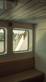 Empty ferry interior with window view, providing a tranquil travel experience at sea.