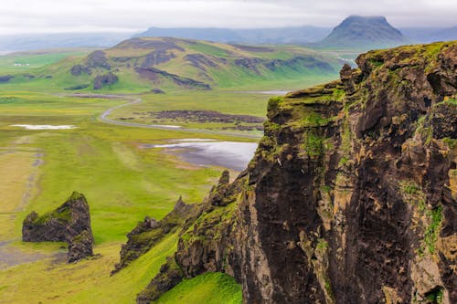 View of Rocky Cliffs and Green Fields of Dyrholaey, Iceland