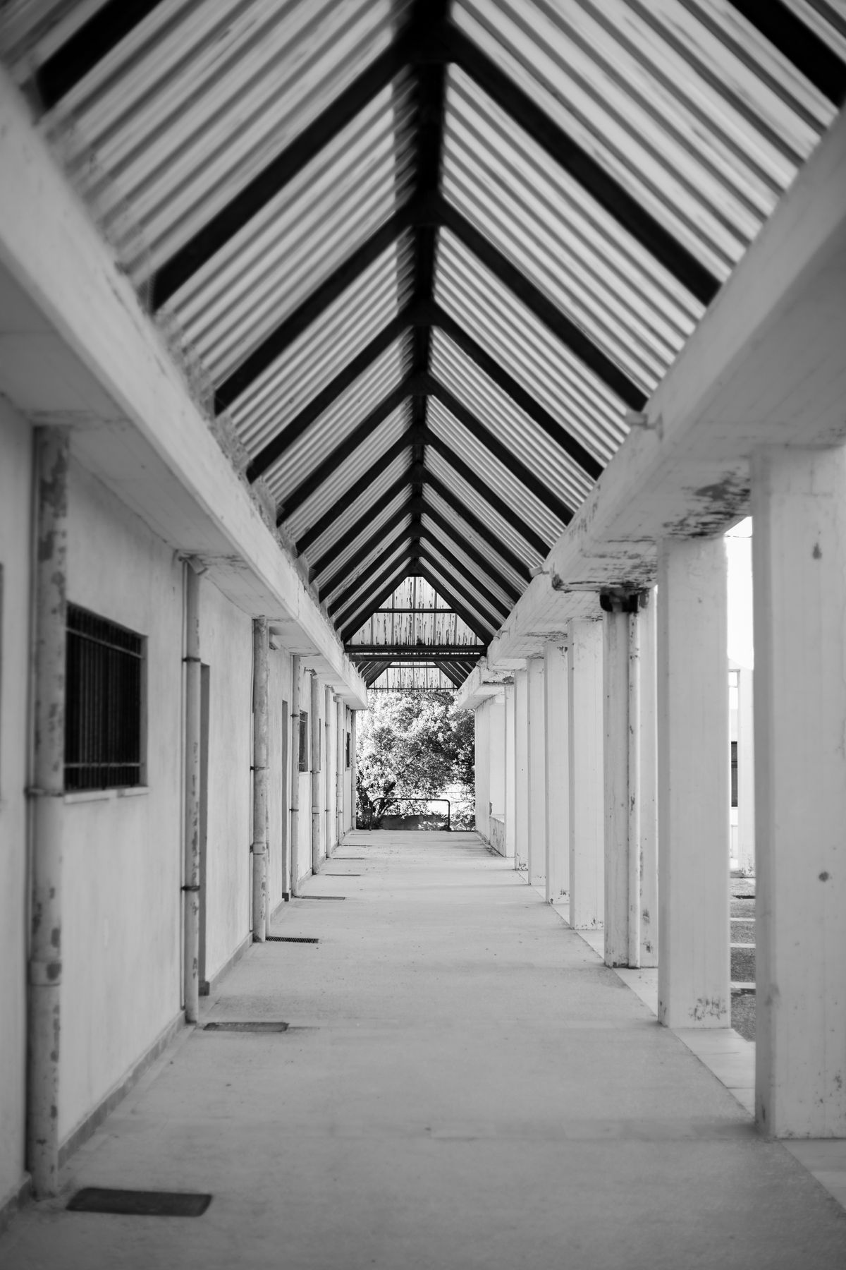 Symmetrical white hallway receding toward a distant door