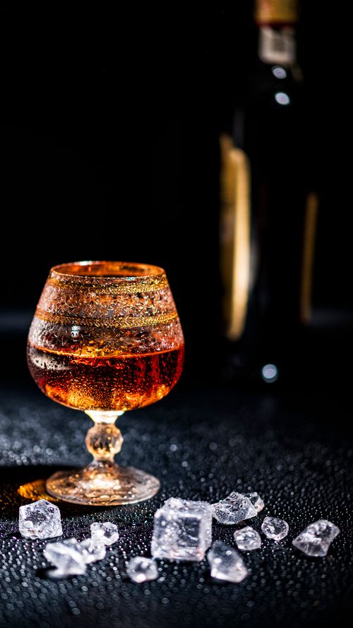 Free Elegant whiskey glass with ice cubes, perfect for luxury and celebration themes. Stock Photo