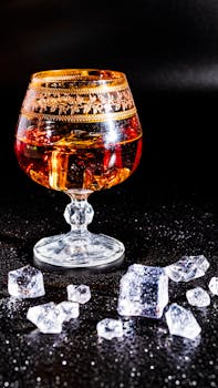 Elegant glass with whiskey and ice cubes, perfect for festive celebrations and luxurious moments.