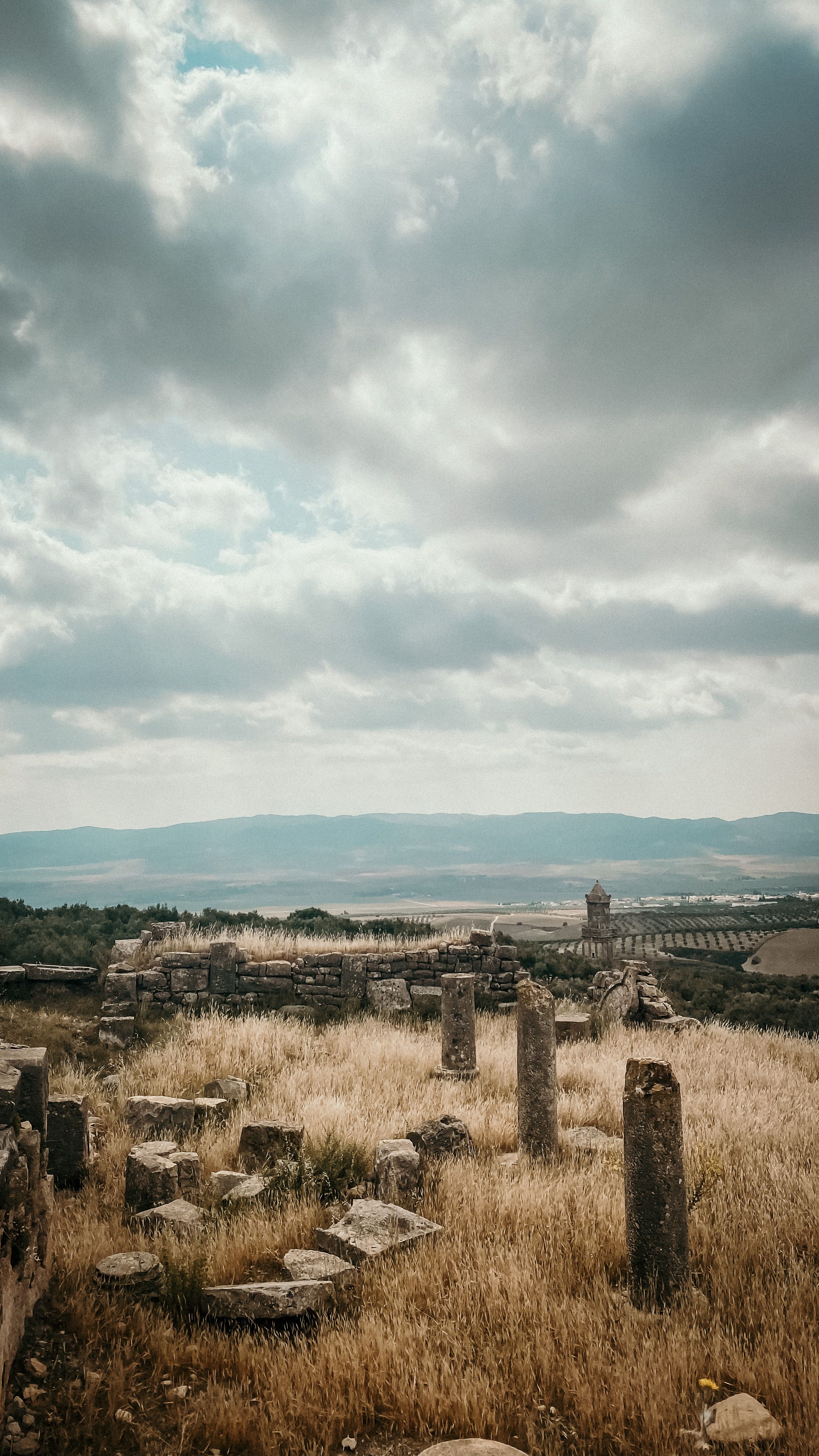 Fotomural Explora las ruinas antiguas de Teboursouk, Túnez, bajo dramáticos cielos nublados.