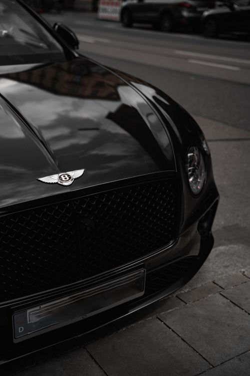 Free Close-up of a luxury black car parked on a city street in Munich, Germany. Stock Photo