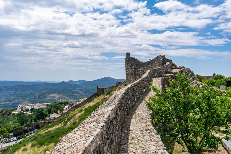 Ancient stone castle walls above a valley by David Rama on Pexels