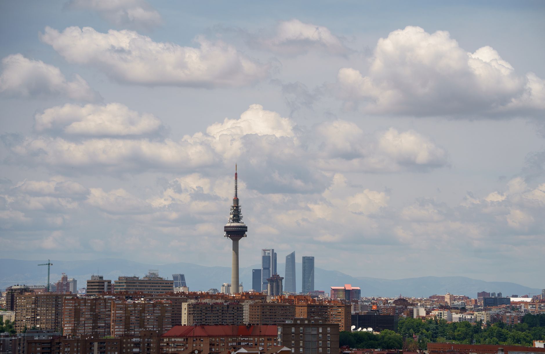 A beautiful view of Madrid's cityscape featuring iconic towers against a cloudy sky.