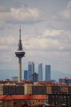 Stunning view of Madrid cityscape featuring the iconic communication tower against a cloudy sky.