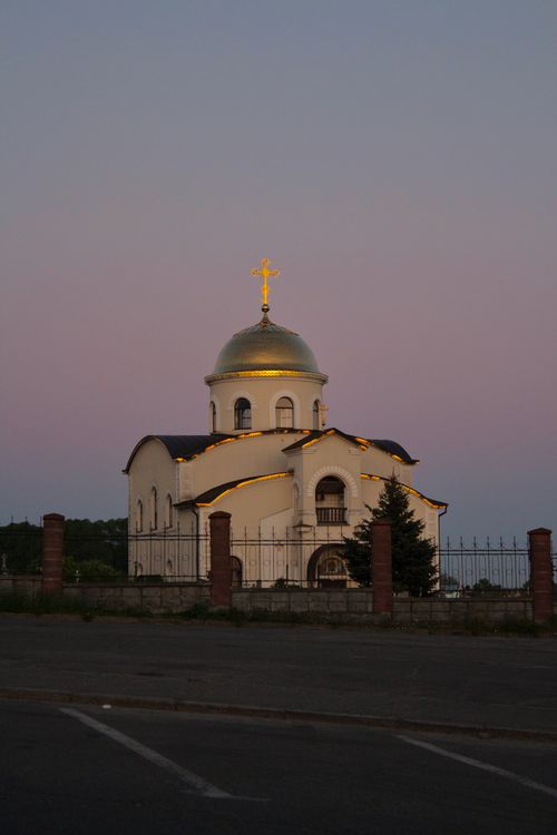 Free A serene view of an Orthodox church at twilight, featuring a golden cross and warm lighting. Stock Photo
