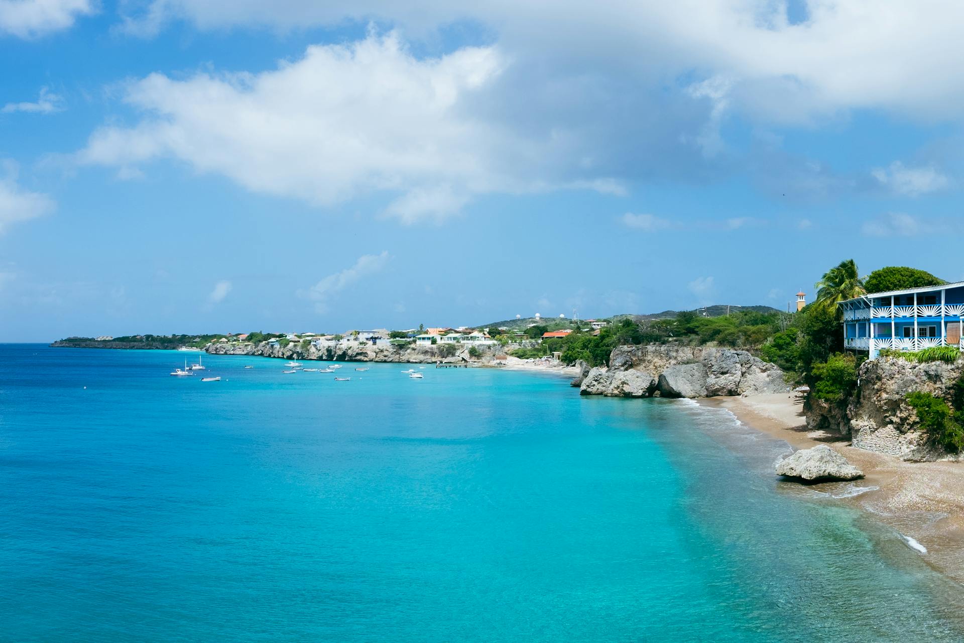 Stunning aerial view of Playa Forti Beach in Curacao with turquoise waters and rocky shorelines.