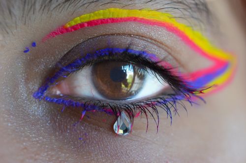 Free Close-up of a woman's eye with colorful eyeliner and jewel detail. Stock Photo
