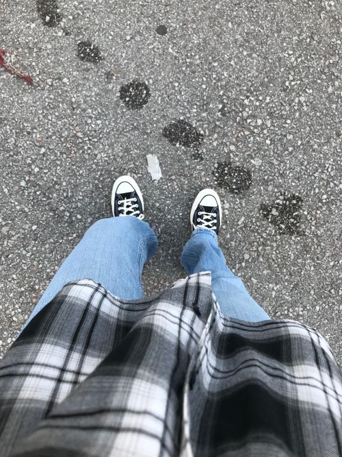 Free Casual attire with plaid shirt and sneakers on gravel. Perfect for lifestyle themes. Stock Photo