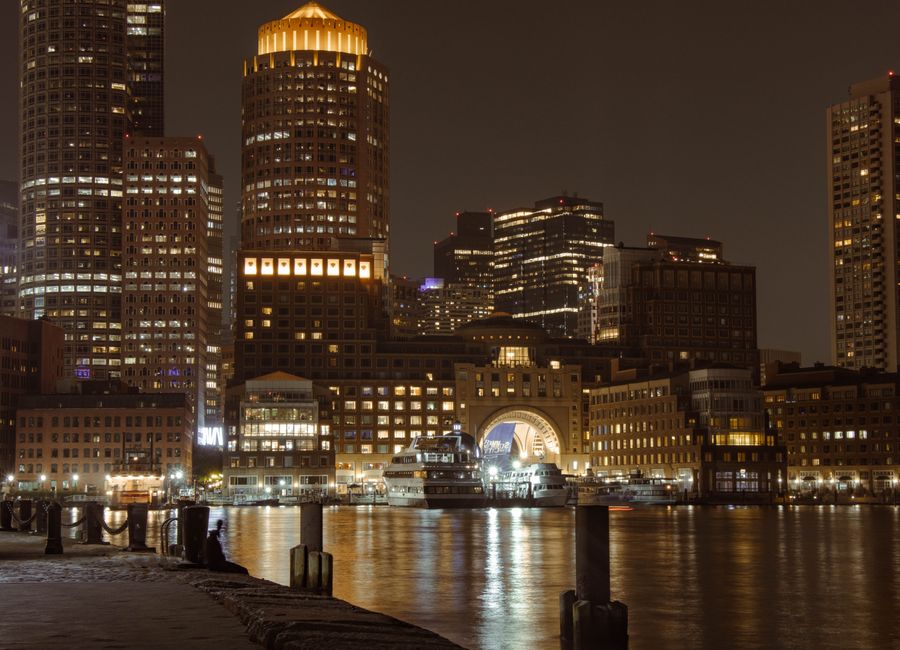 Stunning view of Boston's illuminated skyline and harbor at night showcasing iconic landmarks.