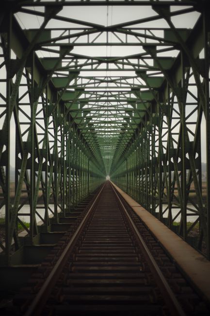 A captivating view down the tracks of a steel railway bridge, showcasing perfect symmetry.