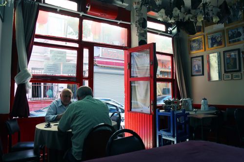 Free Cozy interior of an İstanbul teahouse with a red door and elderly men enjoying tea. Stock Photo