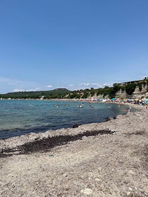 Tourist on Beach under Cliff