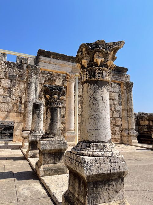 Free Explore the intricate details of ancient synagogue ruins under a bright blue sky in Capernaum. Stock Photo