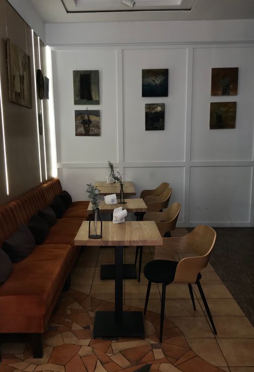 Free A stylish cafe interior featuring modern decor, comfortable seating, and wall art for a cozy atmosphere. Stock Photo