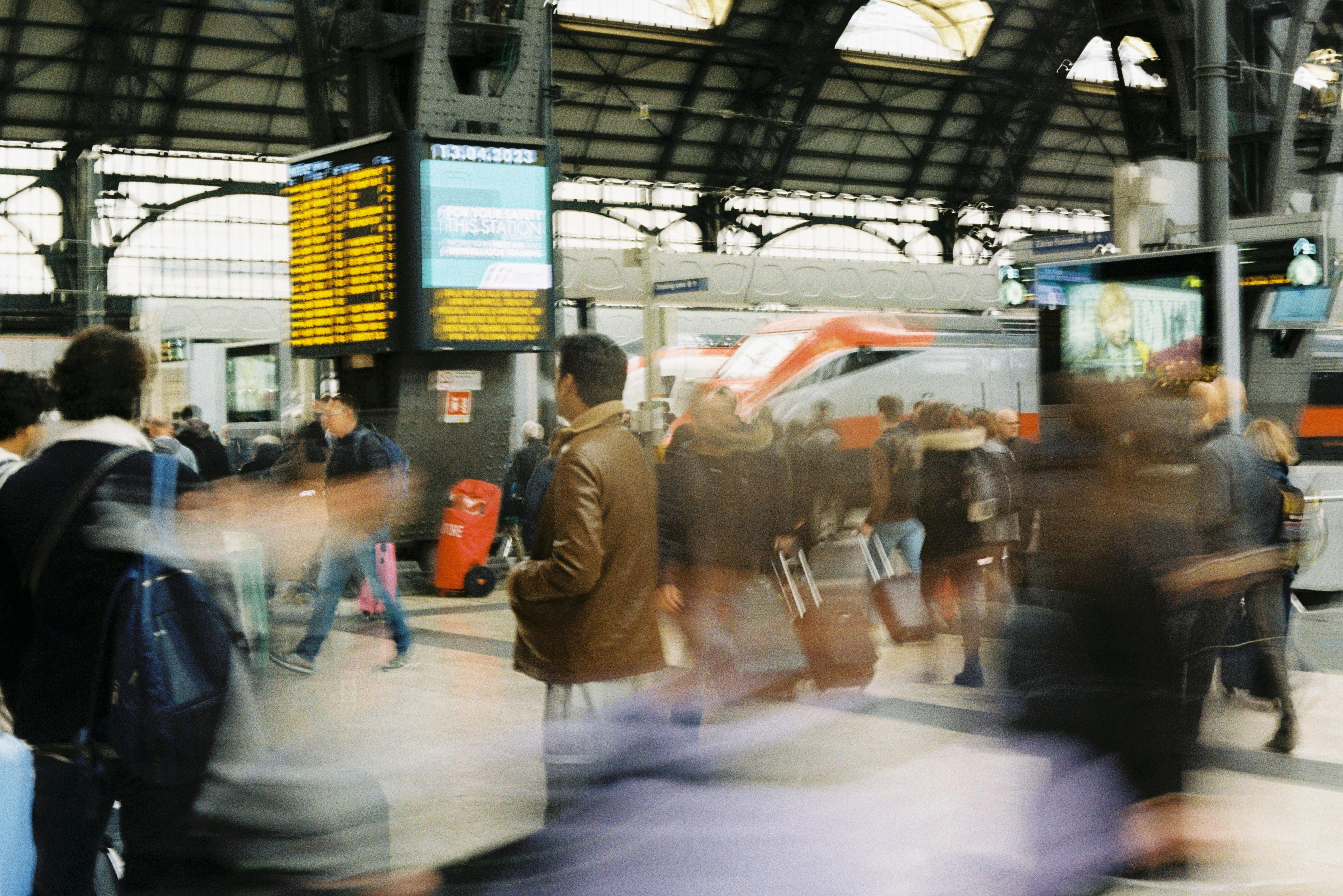 Blurred motion of passengers at a bustling train station in Milan, Italy.