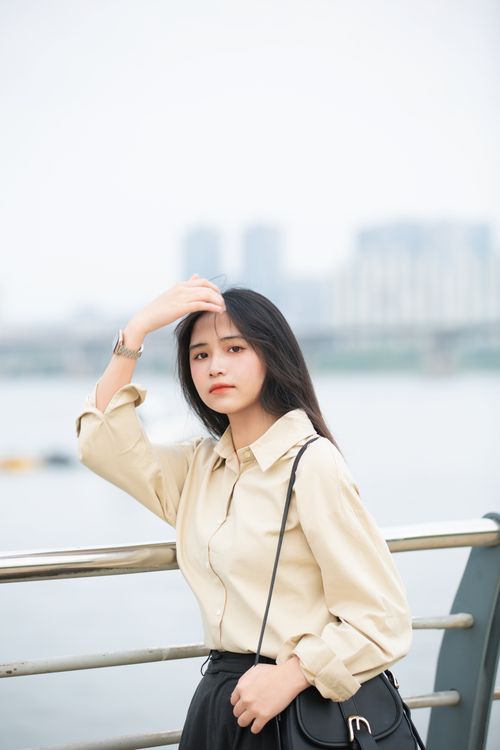 Free A fashionable woman stands by the Han River railing, capturing urban style in Seoul. Stock Photo