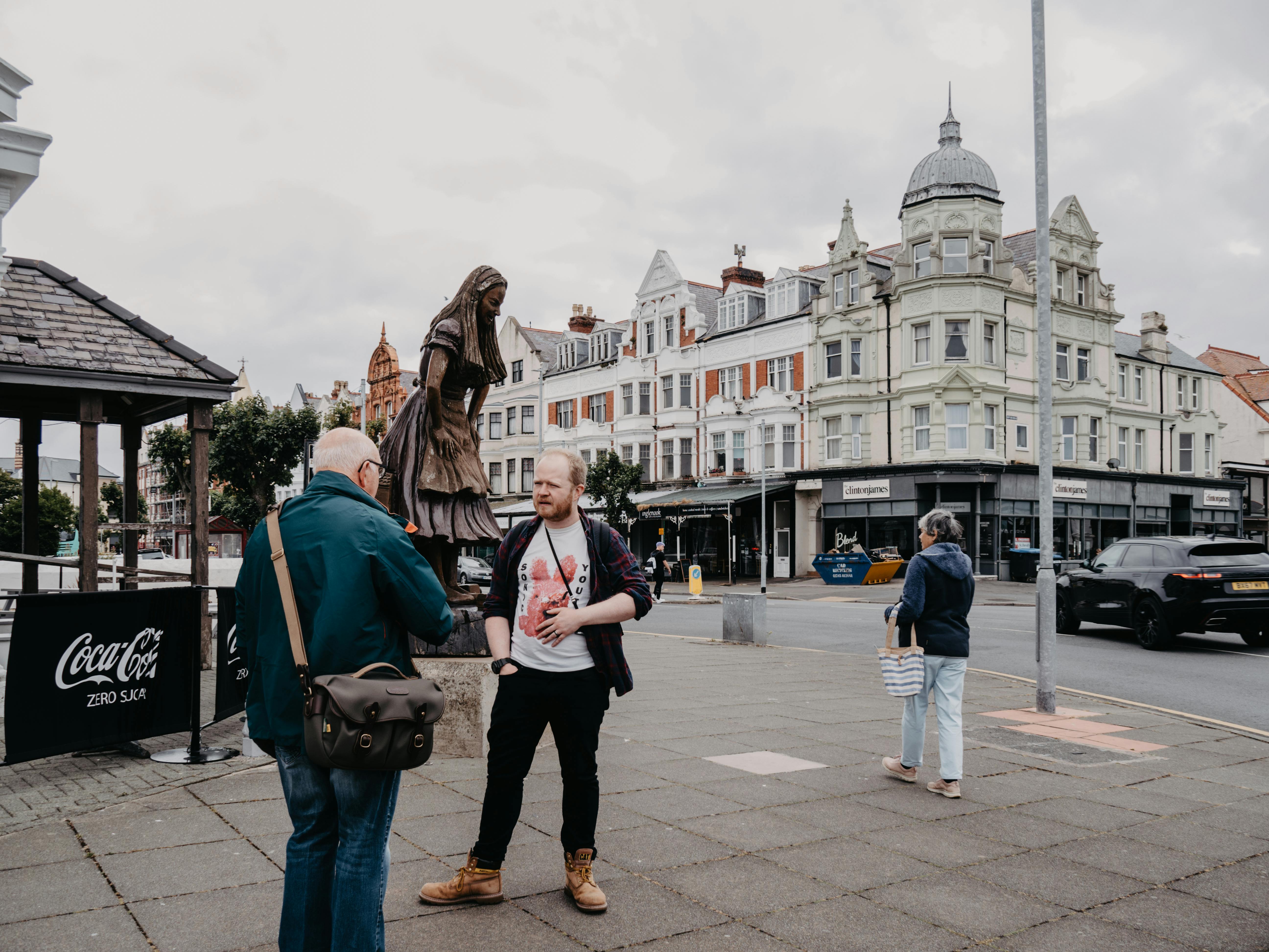 Street view in Llandudno, Wales, featuring locals and historical architecture.