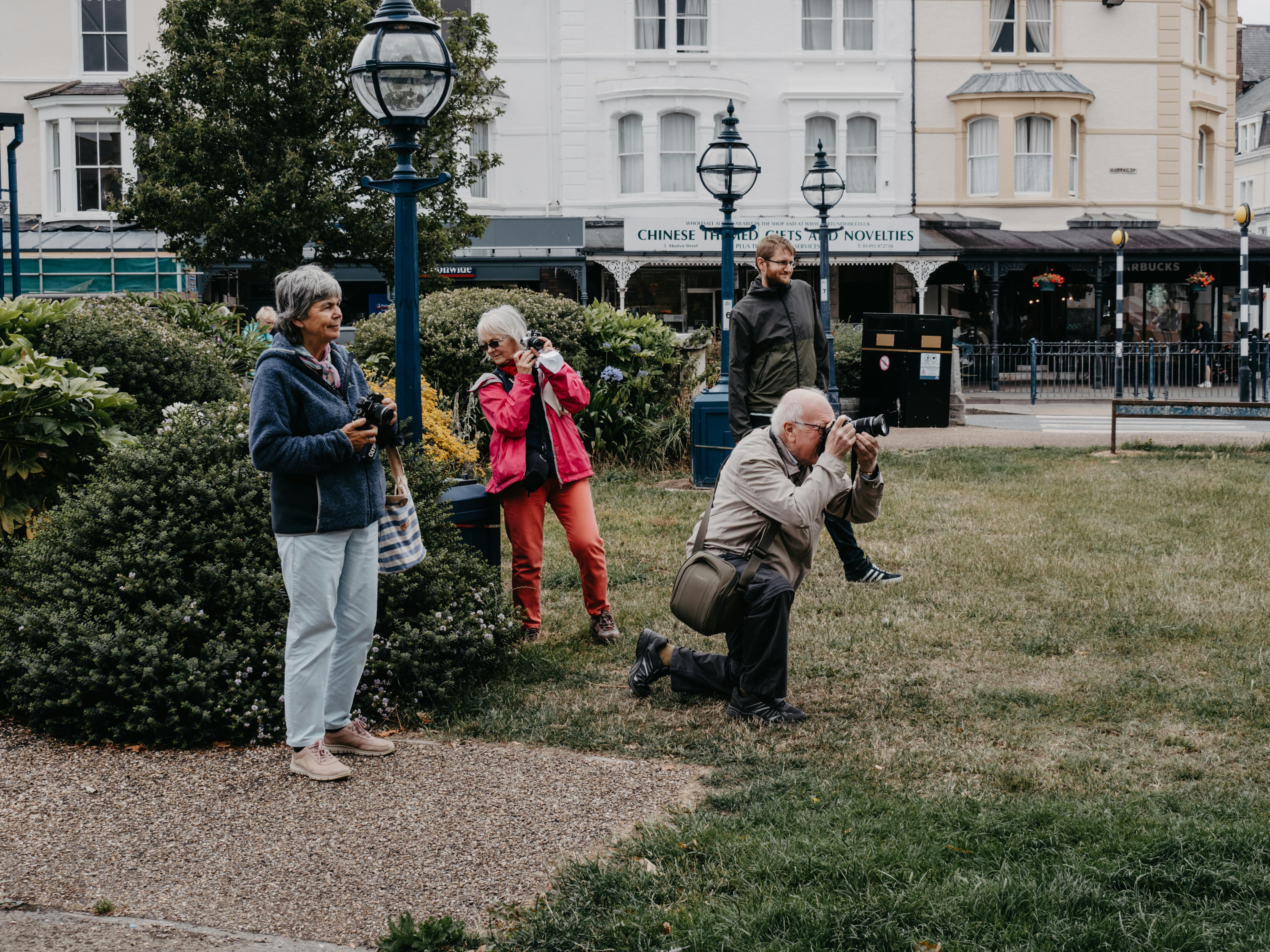 Group of photographers taking pictures in Llandudno, Wales, capturing urban life.
