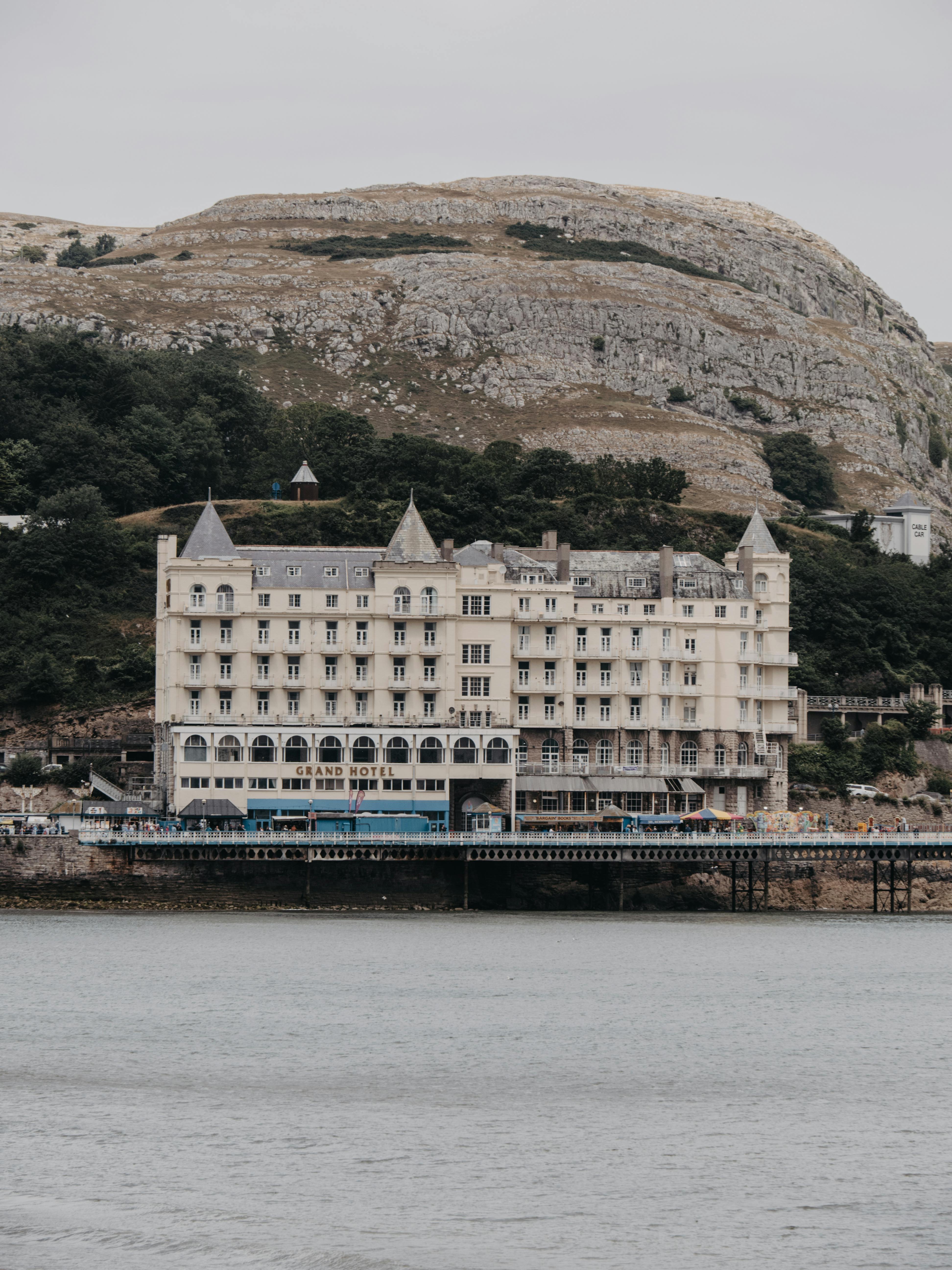 Picturesque view of the Grand Hotel in Llandudno, Wales, with mountain scenery.
