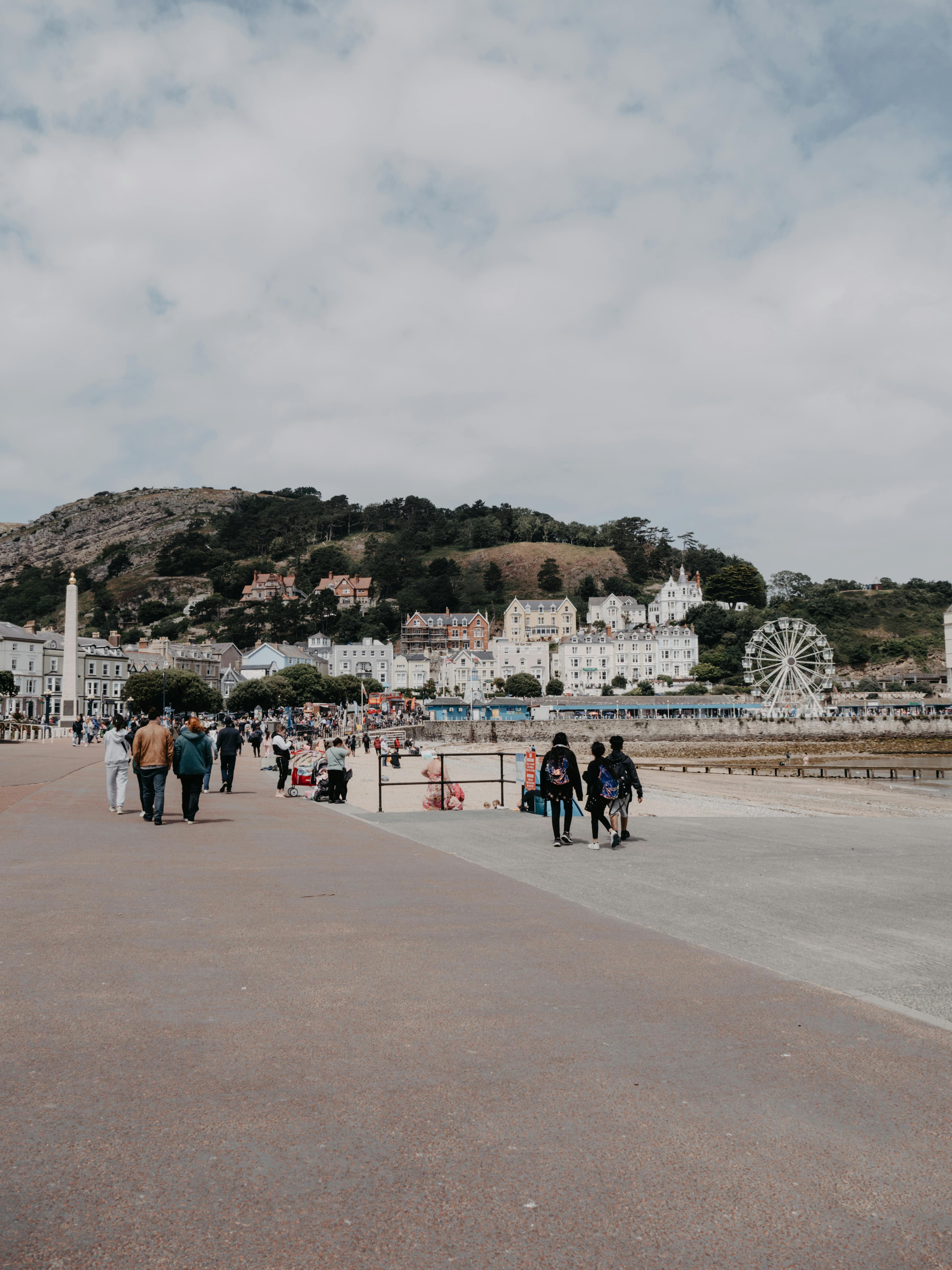 Experience the lively promenade in Llandudno, Wales with a historic Ferris wheel in the backdrop.