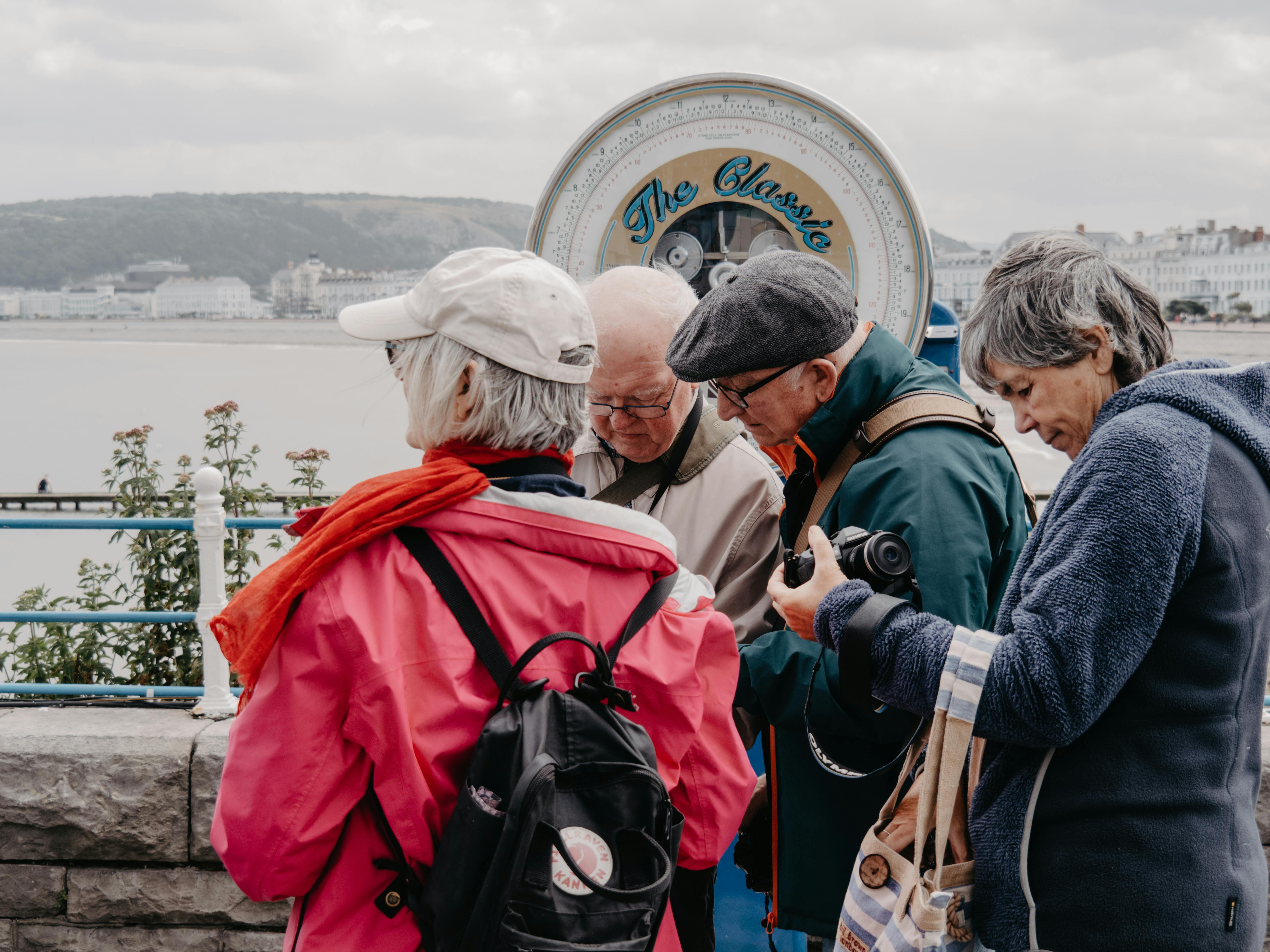 People walking outdoors amongst holiday lights with festive coats on.