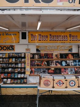 Explore a vibrant outdoor market stall featuring vinyl records and books in a nostalgic setup.