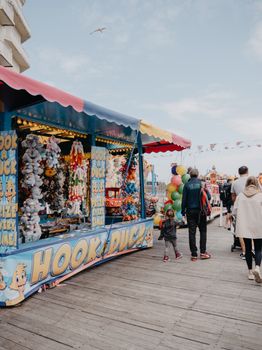 Colorful carnival games and families enjoying a walk on Llandudno Pier in Wales.