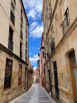 Explore the serene charm of a narrow alleyway between old buildings in a historic urban town.
