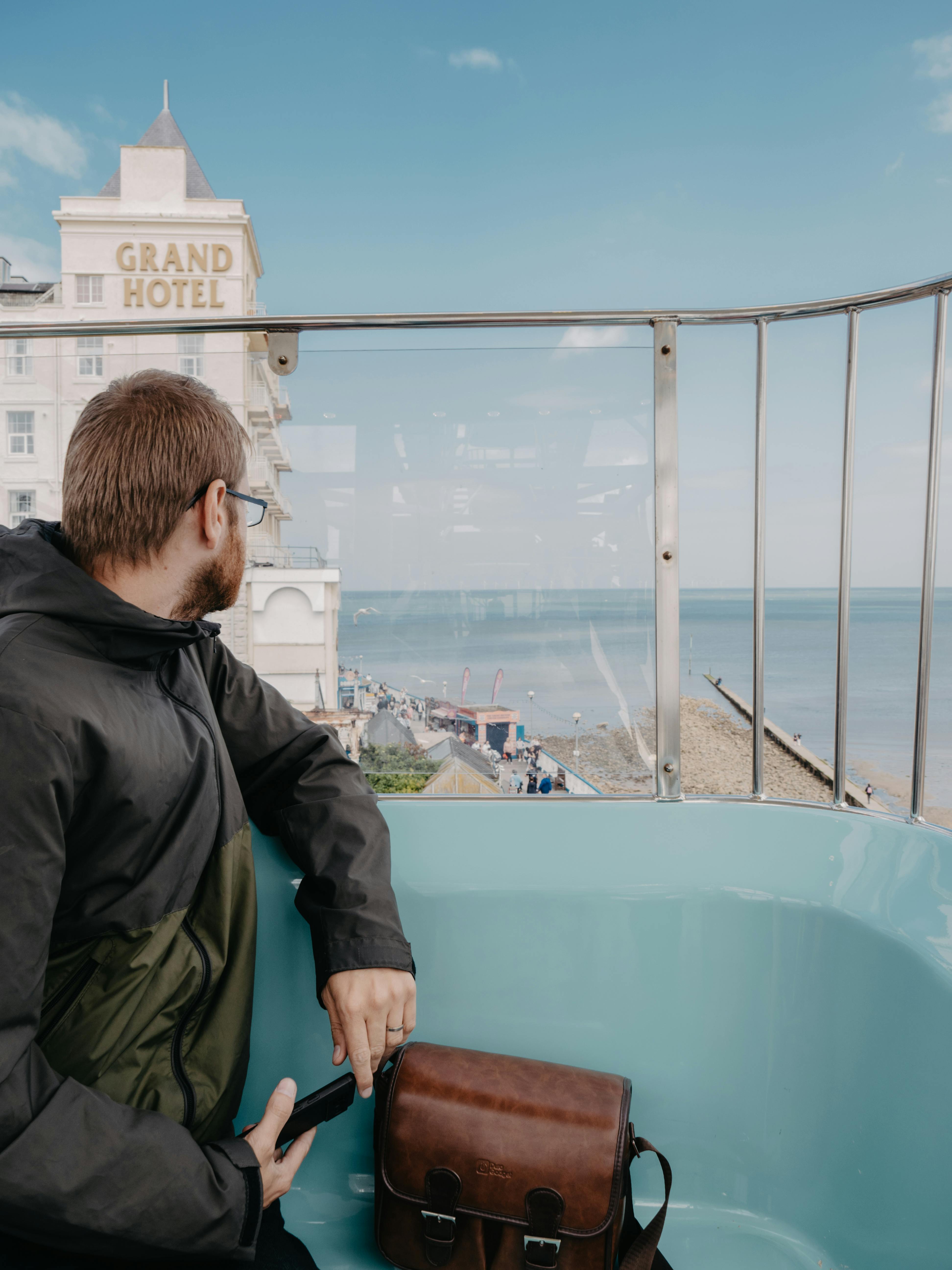 Man on Ferris wheel in Llandudno, Wales, enjoys the coastal view near Grand Hotel.