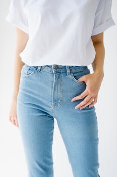 Stylish casual outfit featuring a white top and blue jeans. Simple and elegant fashion photography.