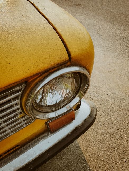 Detailed view of a vintage yellow car headlight with classic design.