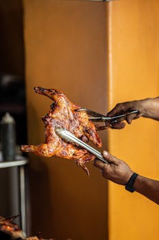 Close-up of a grilled chicken being served, showcasing delicious crispy skin and cooked perfection.