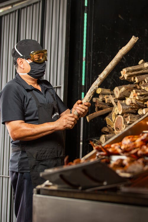 Man Roasting Chicken on a Barbecue