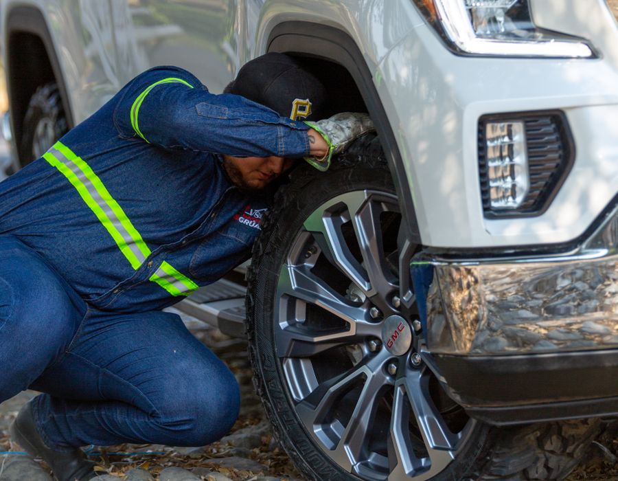 Technician in hi-vis working on a wheel on site