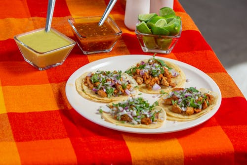 Plate of Tacos and Two Dipping Sauces on a Checked Tablecloth