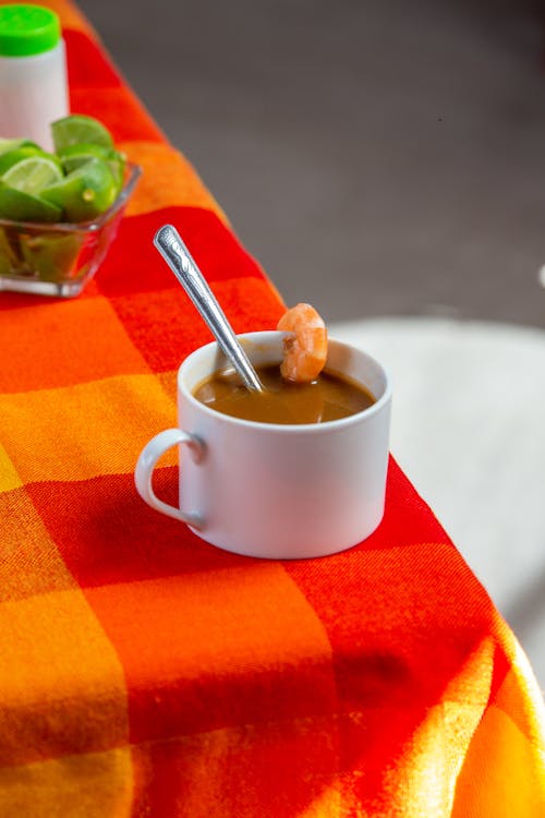 Brown Drink in a White Mug with a Prawn on the Edge