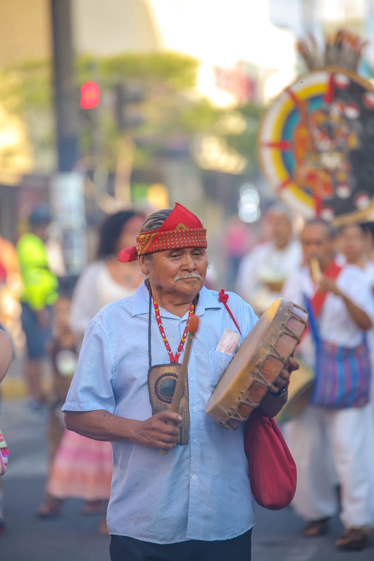 Senior Man Playing A Drum On The Street