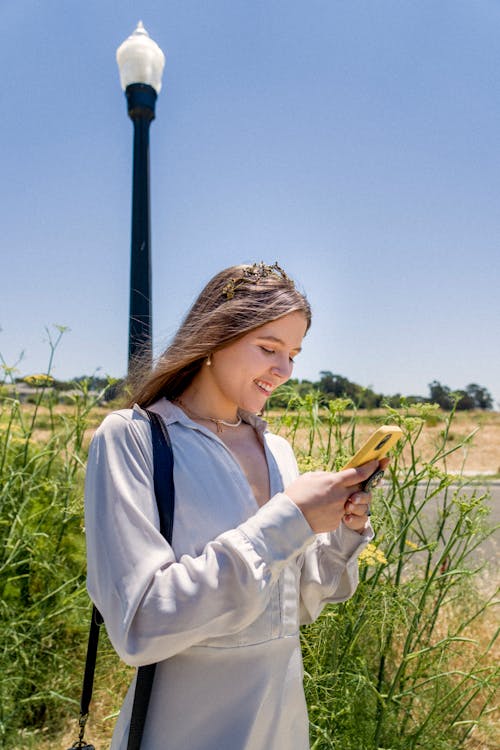 Smiling Woman Using Smartphone in Countryside