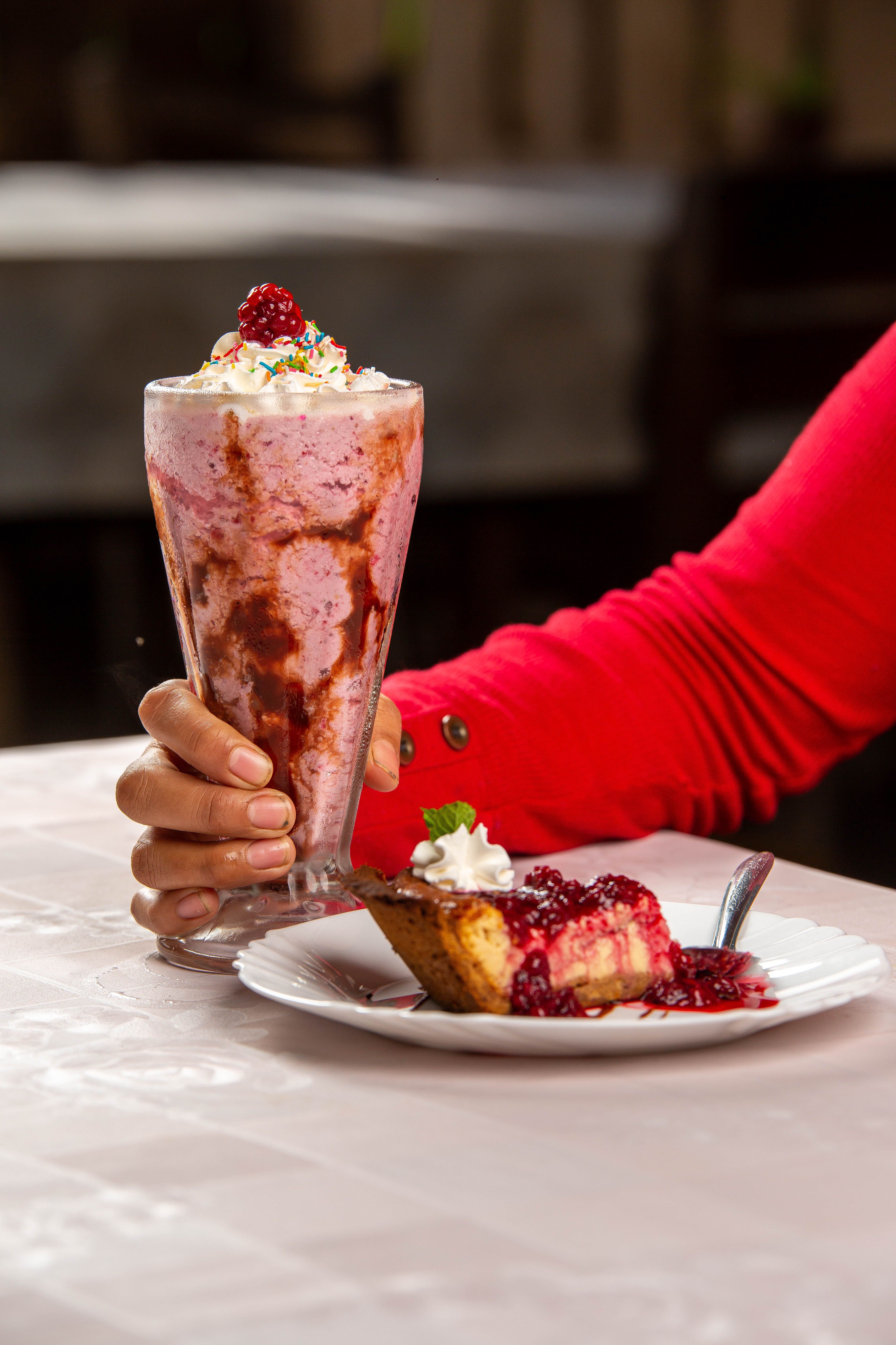 Tempting strawberry milkshake and cake with vibrant berry toppings, perfect for dining inspiration.