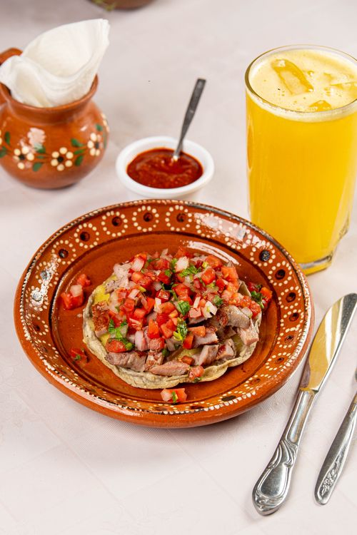 Free Delicious homemade Mexican tostada topped with fresh salsa, served with orange juice. Stock Photo